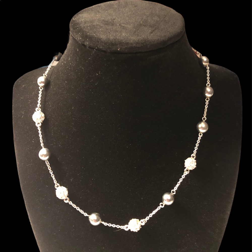 Silver tone necklace with light blue beads.